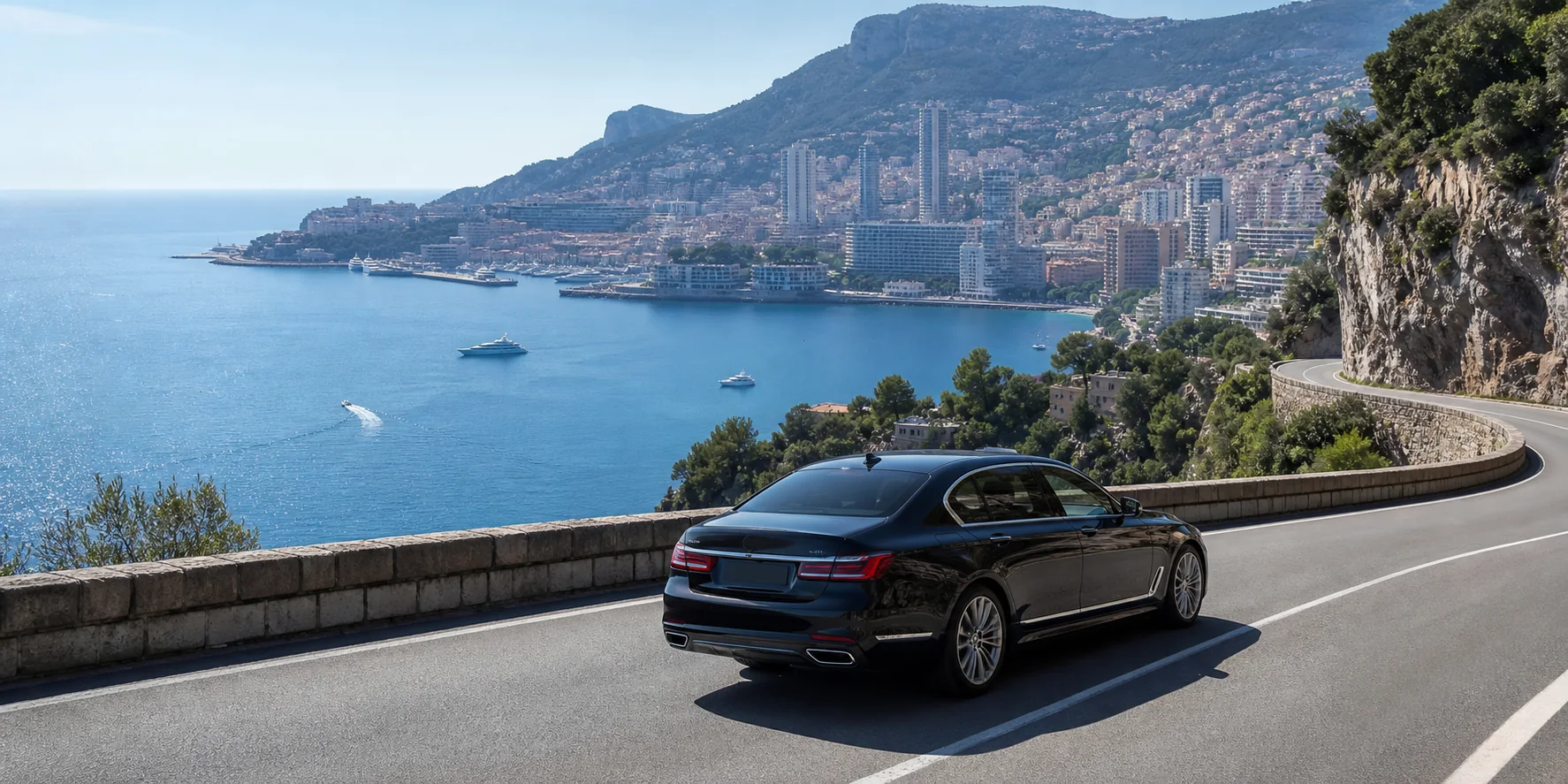 Black chauffeur sedan on the coastal road above Monaco for a Nice Airport transfer